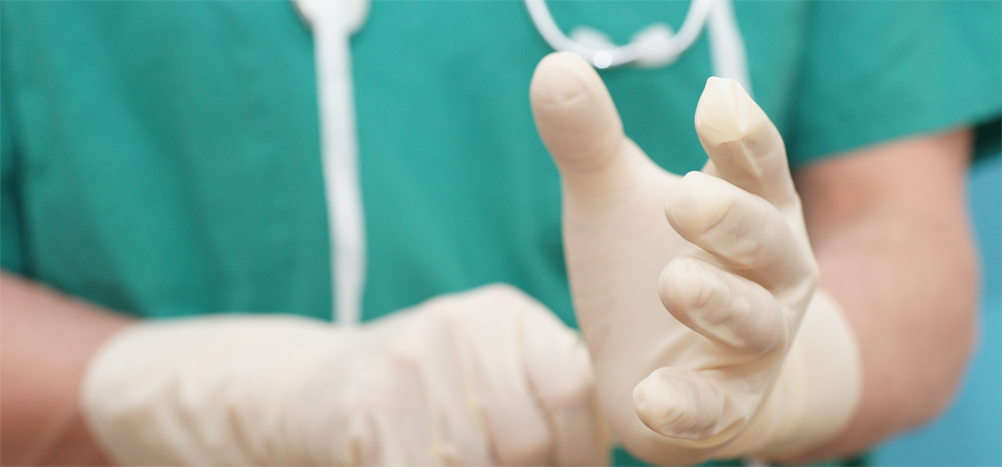 Chirurg streift sich Handschuhe über